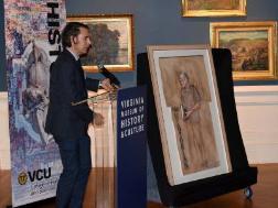 andrew crislip at podium with portrait of blake